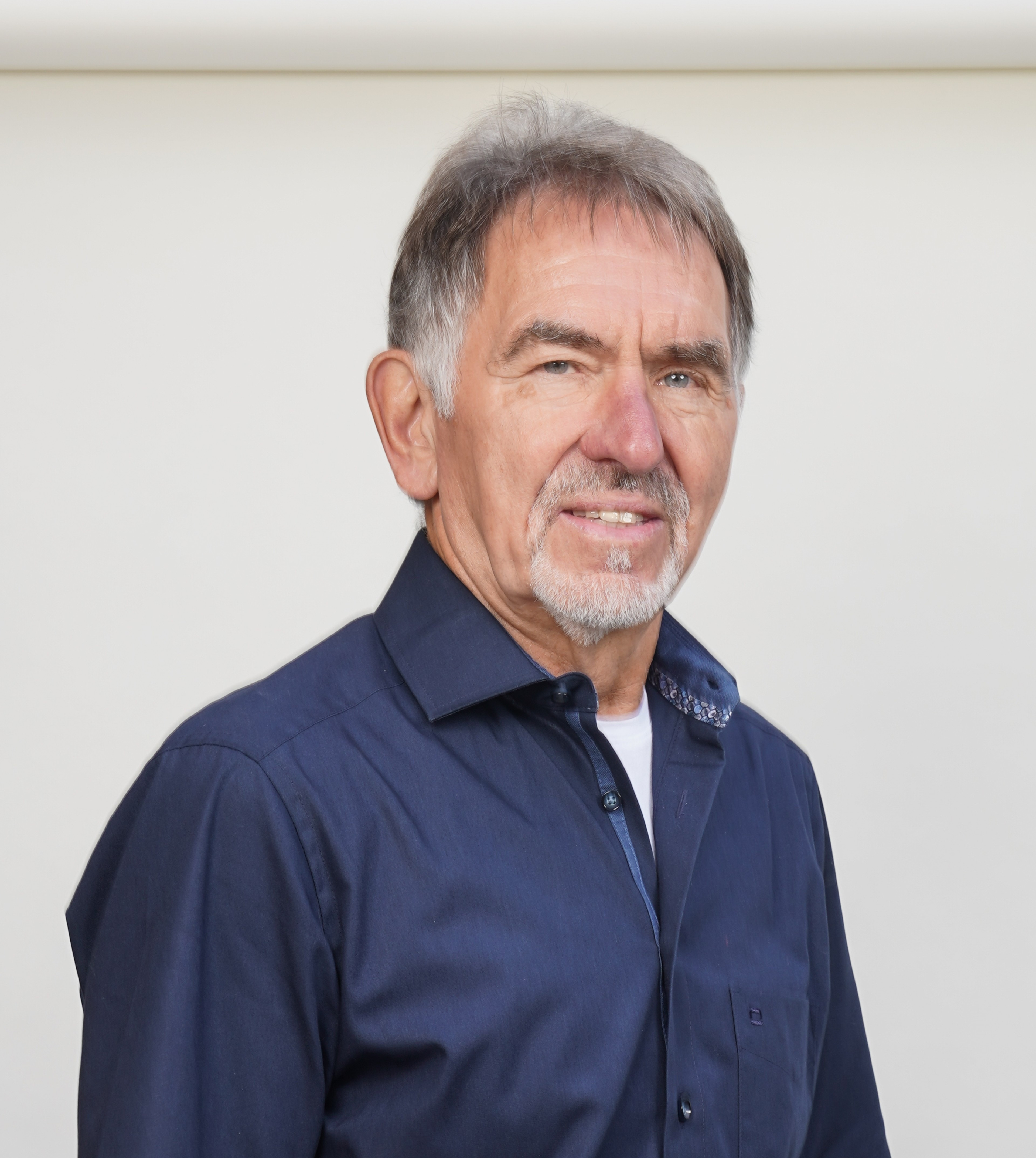 Ekkehart Friedrich im blauen Hemd vor hellem Hintergrund
