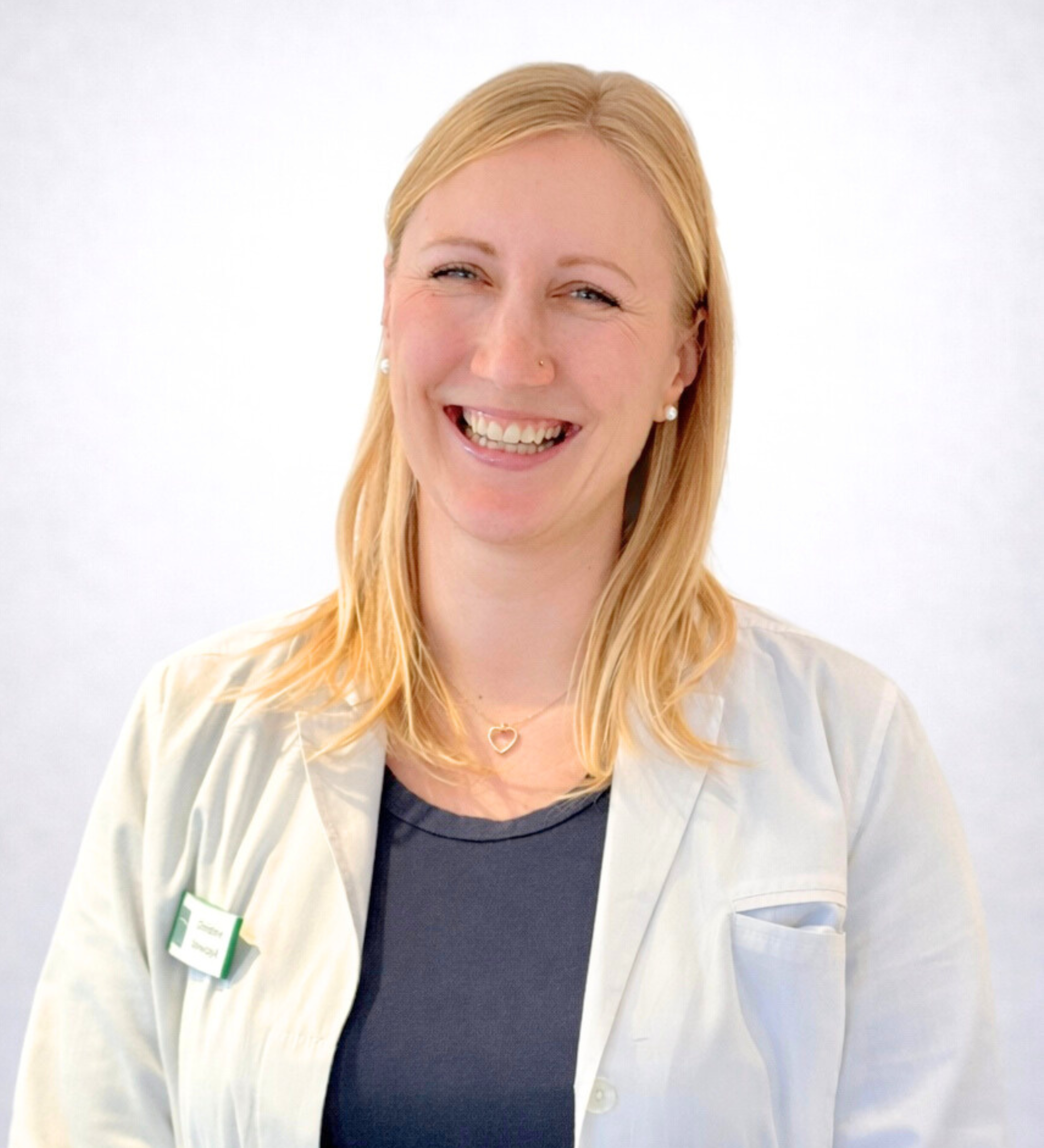 Teamvorstellung: Mitarbeiterin im weißen Kittel mit Namensschild