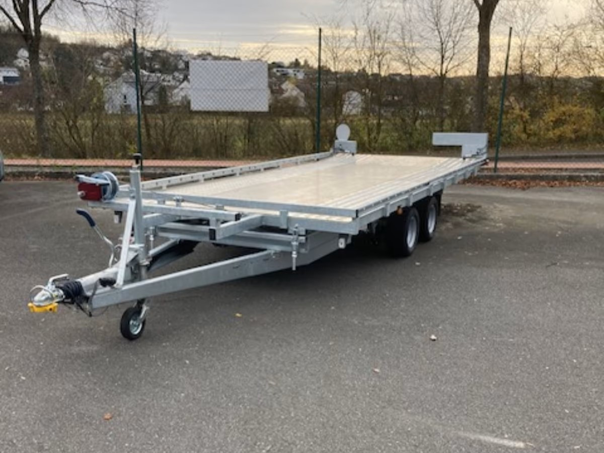 Autotransporter Farmperfekt Mietanhänger auf Parkplatz – offener PKW-Anhänger zur Fahrzeugbeförderung