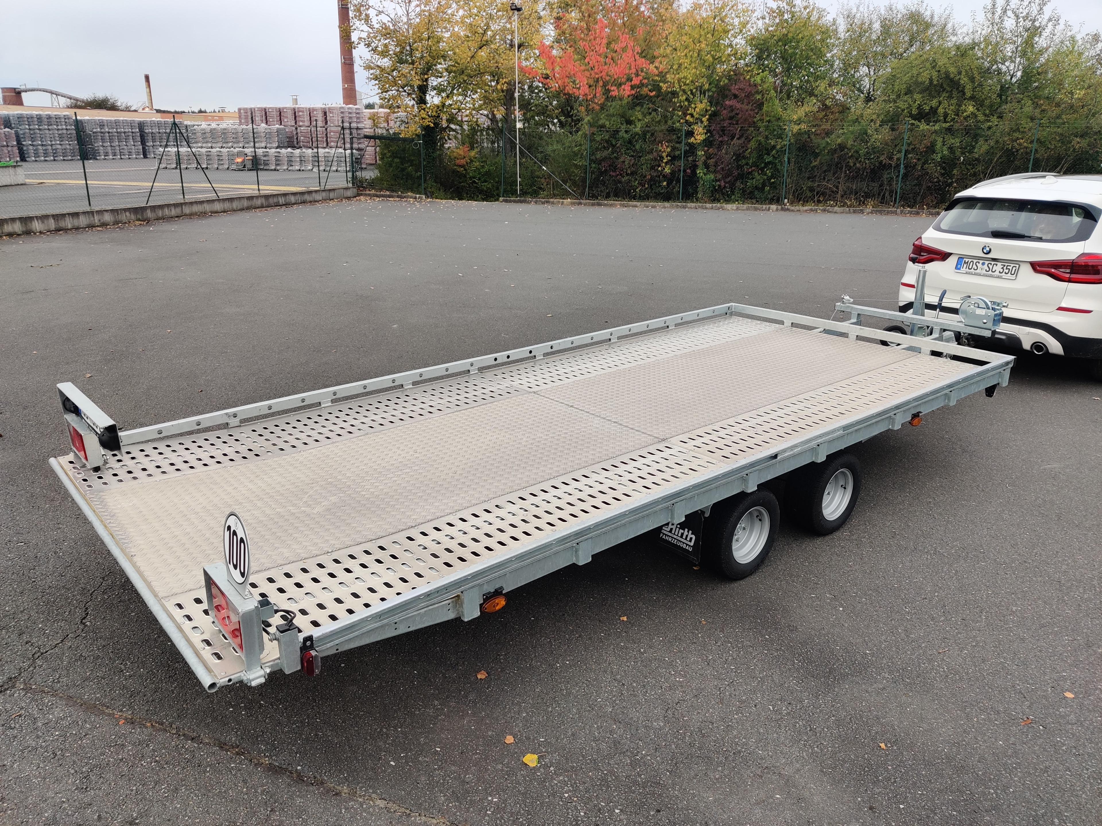 Autotransportanhänger mieten bei Farmperfekt Anhängervermietung – offener Autotransportanhänger auf Parkplatz