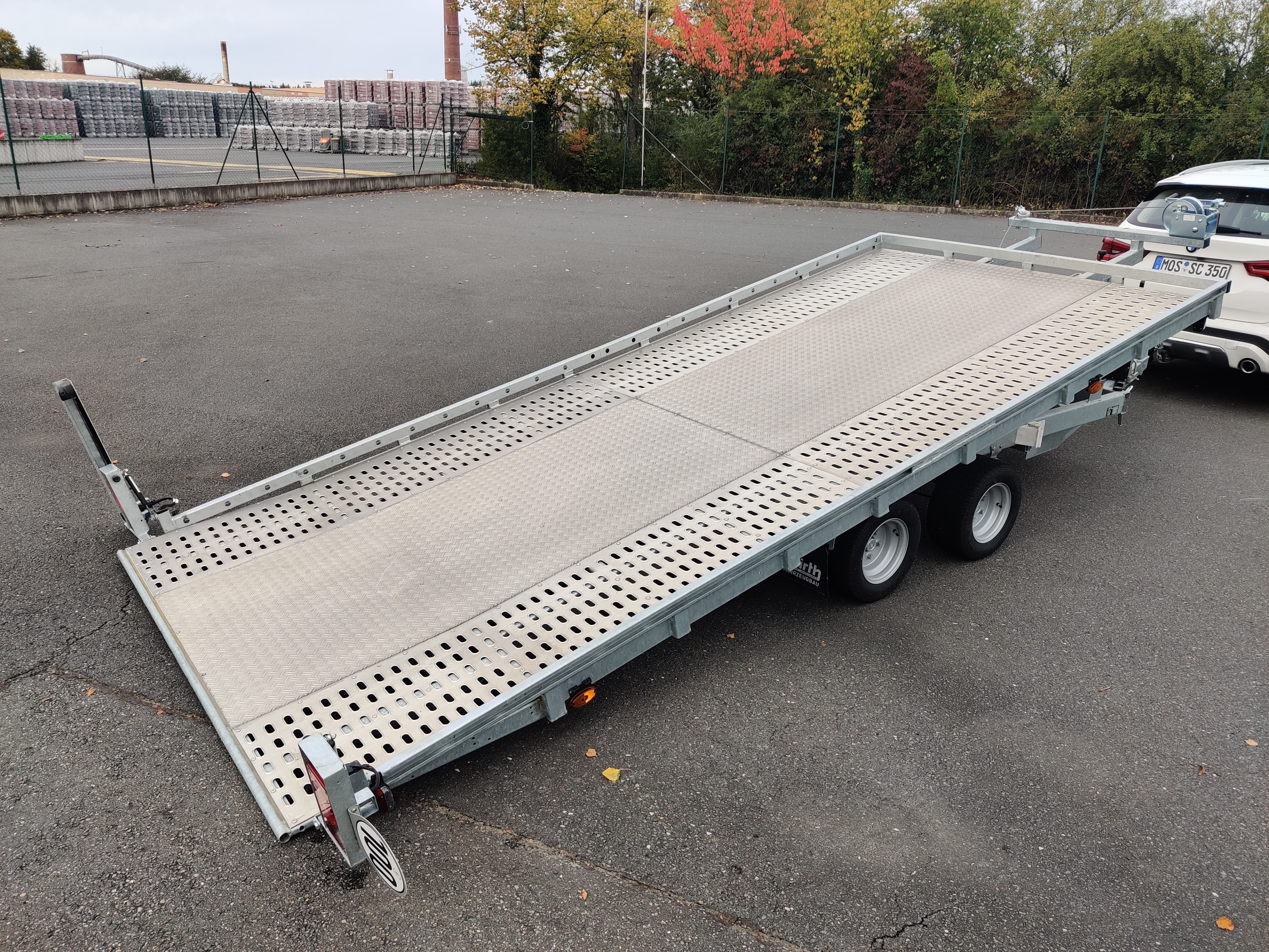 Gekippter Autotransporter Leihanhänger von Farmperfekt auf einem Parkplatz