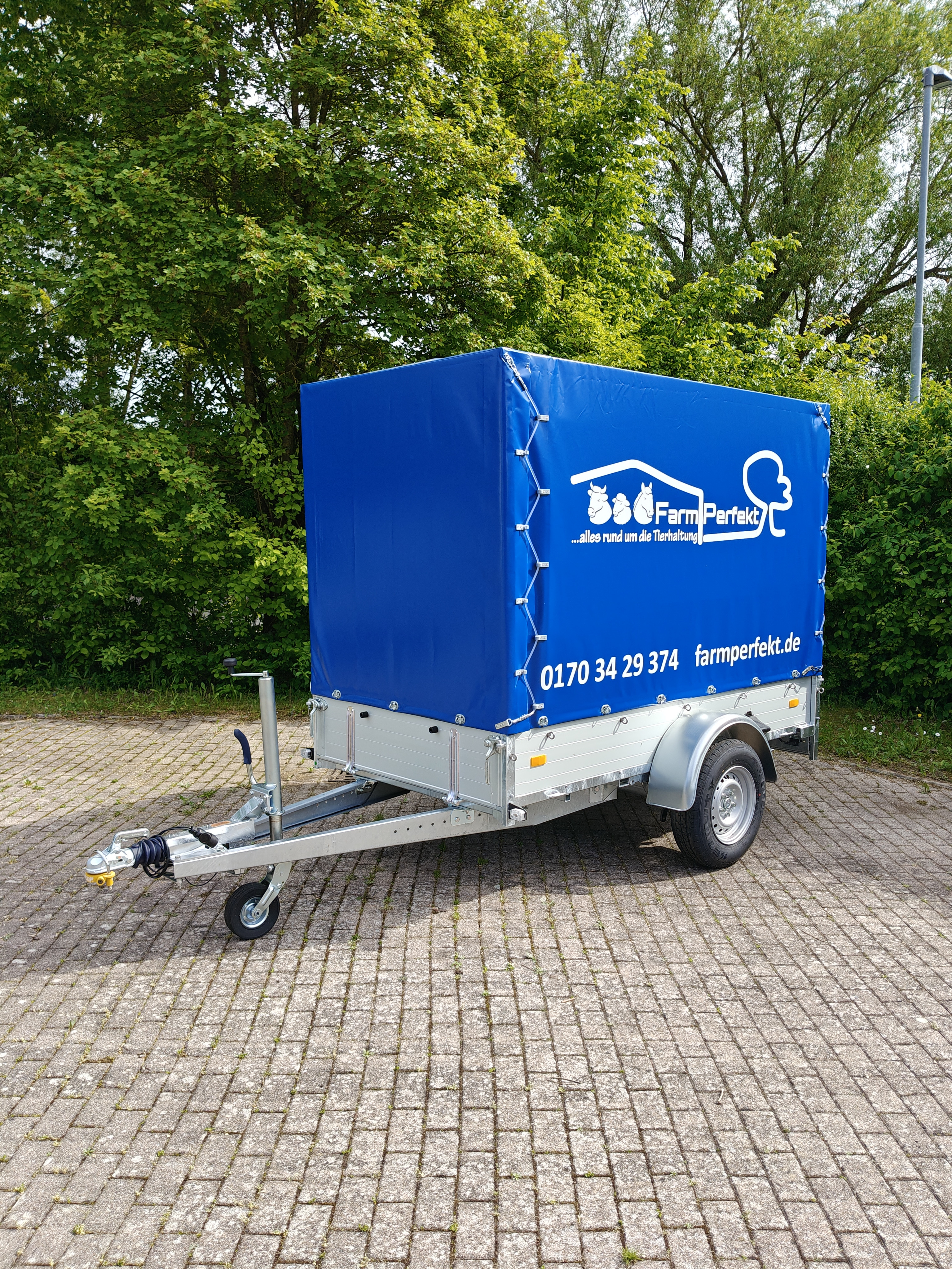 Anhänger mit blauer Plane und FarmPerfekt Werbung, Tierhaltung, farmperfekt.de