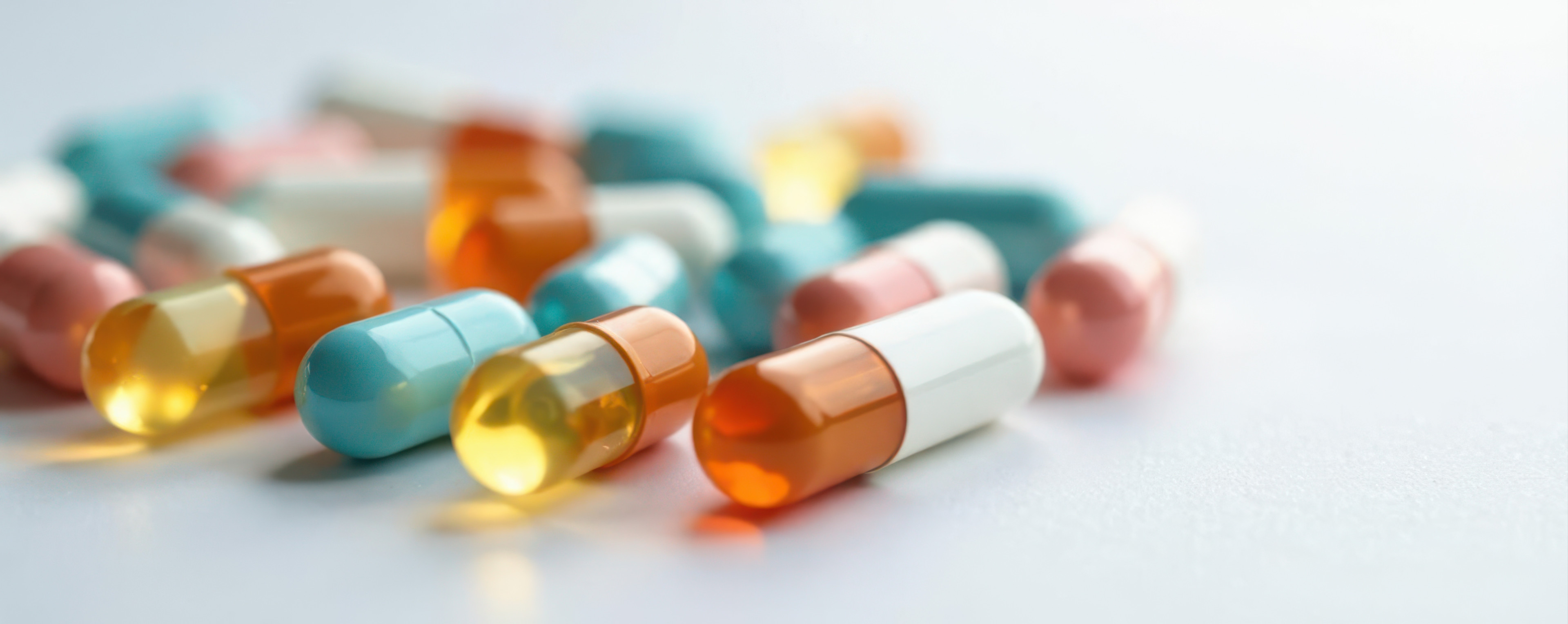 Verschiedene bunte Kapseln und Tabletten auf weißem Hintergrund, Nahaufnahme