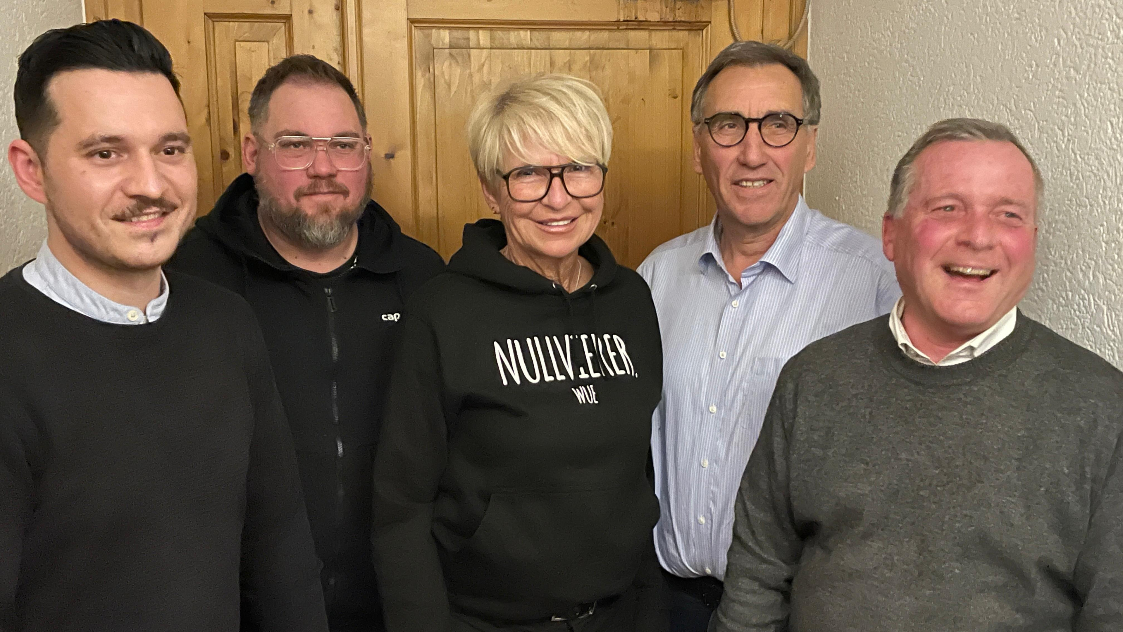 Personengruppe vor Holztür, Frau mit NULL!ECKER WUE Hoodie